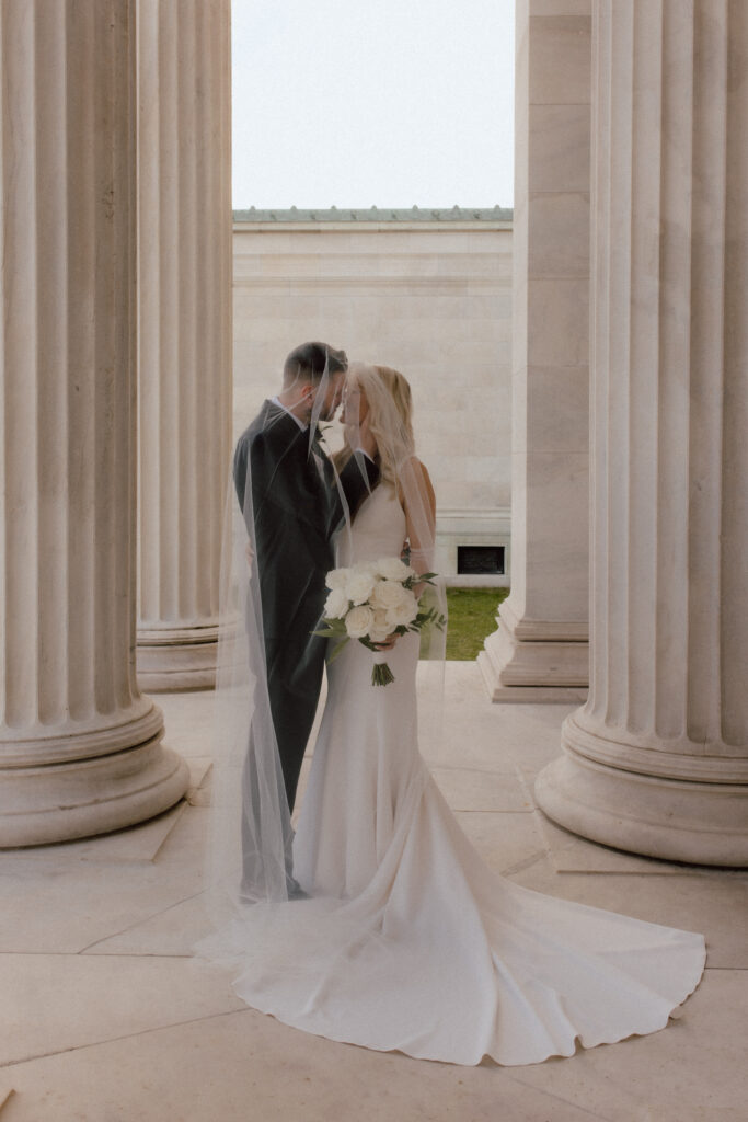 Bride and groom under a veil during their portrait session holding A close photo of a bride holding Catherine Rose florals