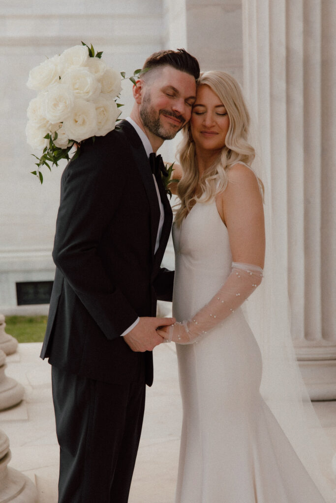 A photo of a bride and groom holding Catherine Rose florals