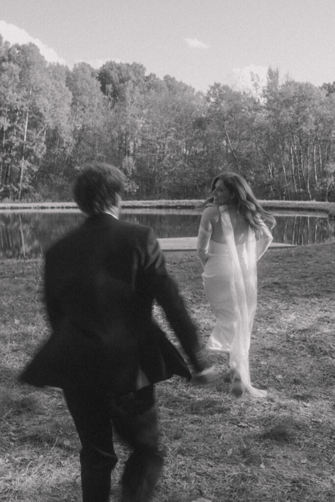 Emma and Ryan laughing together during a couples portrait session by the cabin surrounded by autumn foliage in Great Valley, NY