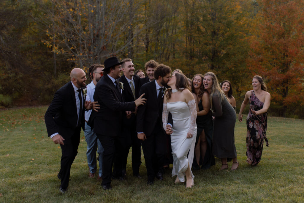 Emma with her bridesmaids and Ryan with his groomsmen smiling together at HoliMont Ski Resort during their Great Valley, NY wedding.