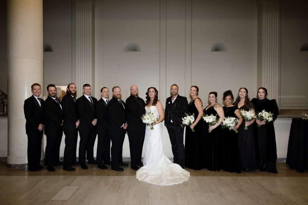 Wedding party portrait during a Hanny Manny Building wedding with the couple surrounded by their bridesmaids and groomsmen in Olean, NY
