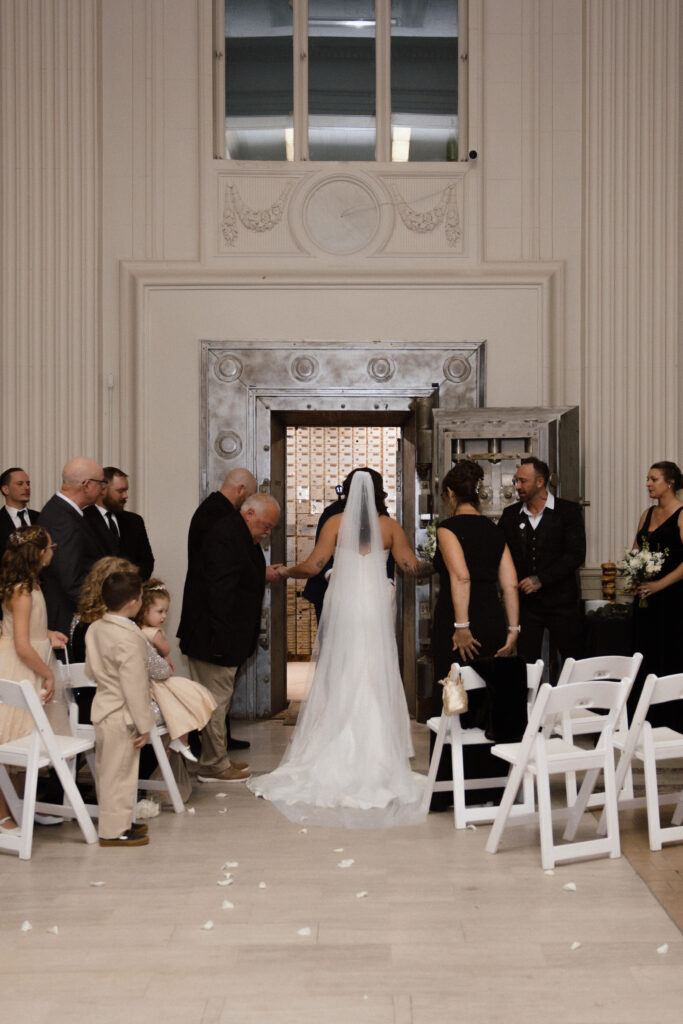 Bride walking down the aisle with her father during a Hanny Manny Building wedding in Olean, NY